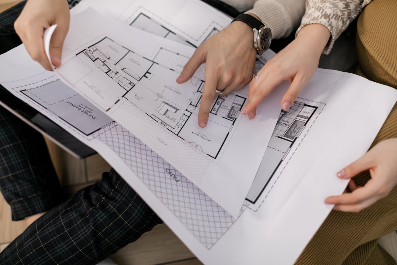 Services Two people examining architectural blueprints, focusing on project details.